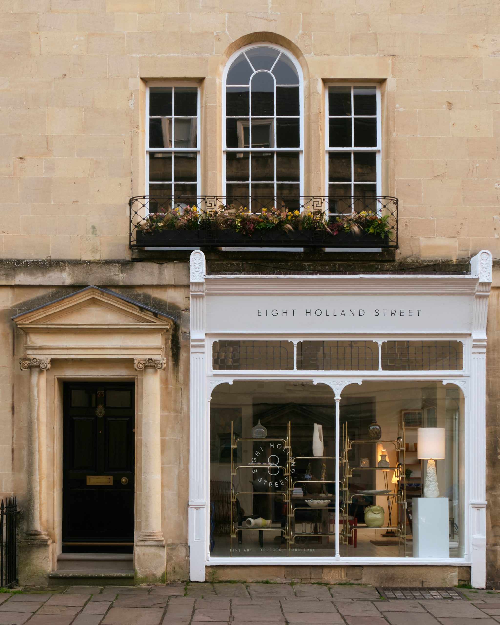 Facade of the 8 Holland Street shop in Bath, UK, featuring a Georgian-style stone building with large display windows and elegant architectural details.